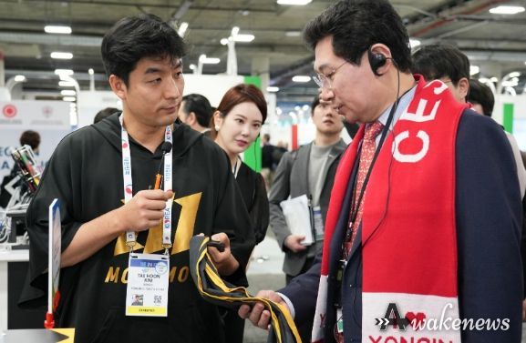 이상일 용인특례시장이 야구 투구 연습 도구 '자이로스피드'를 개발한 마고의 김태훈 대표로 부터 제품 설명을 듣고 있다.