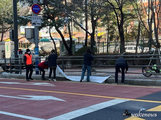 기흥구 관계자가 학교주변 불법광고물을 정비하고 있다.