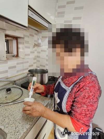 어르신이 음식의 염도를 재고 있다.