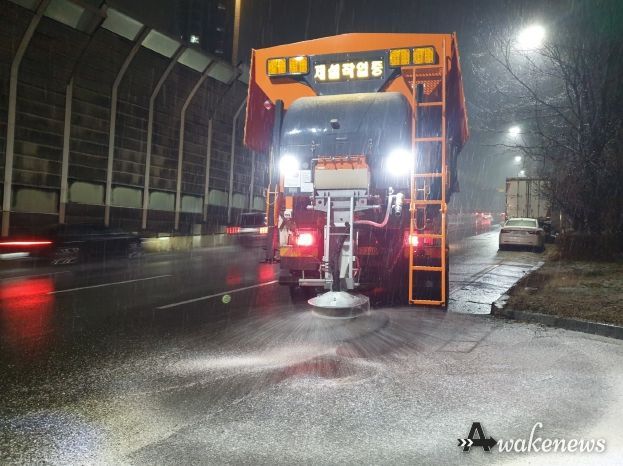 수원시가 13일 저녁 제설차량을 운행하며 제설제를 살포하고 있다.