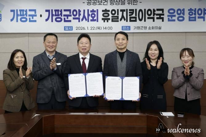 서태원 가평군수(사진 왼쪽에서 세번째)와 안병현 가평군약사회 회장(〃 네번째) 등이 22일 휴일지킴이약국 운영 협약식 후 협약서를 보이며 기념촬영을 하고 있다.