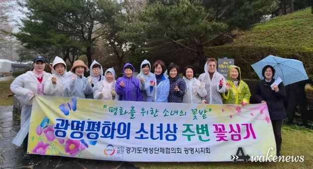 광명시 여성단체협의회가 10일 광명동굴 입구에 설치된 평화의 소녀상 주변에 봄꽃 300그루를 심고 기념사진을 촬영하고 있다.